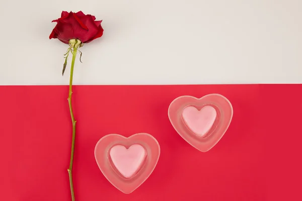 Rose on a white background and two candles on red background — Stock Photo, Image