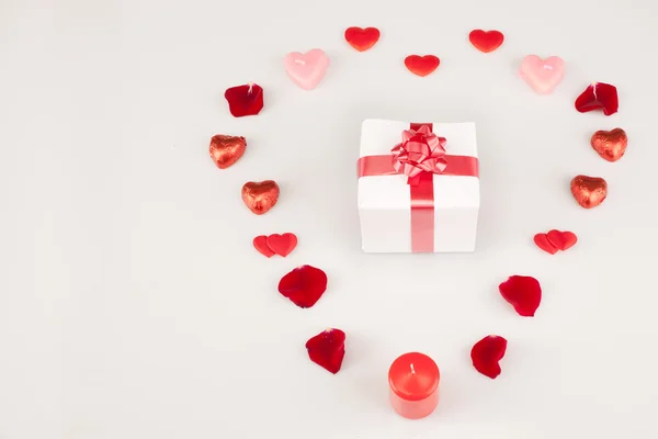 White gift and a lot of hearts on a white background — Stock Photo, Image