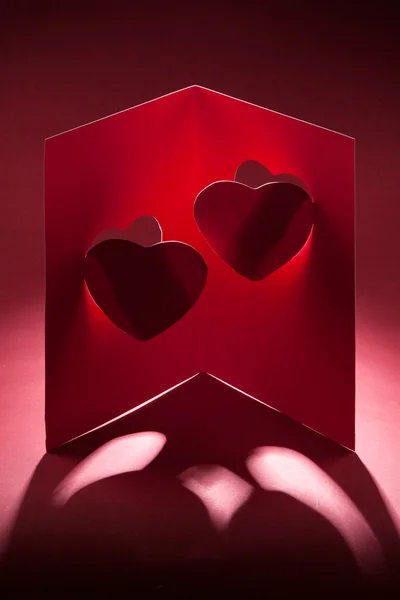 Kort till alla hjärtans dag med två hjärtan på en röd bakgrund — Stockfoto