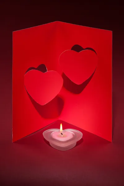 蜡烛和一张卡片，在红色的背景上的两颗心情人节 — 图库照片
