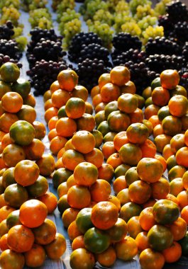 Oranges, grapes in Bangalore Fruit market, India clipart