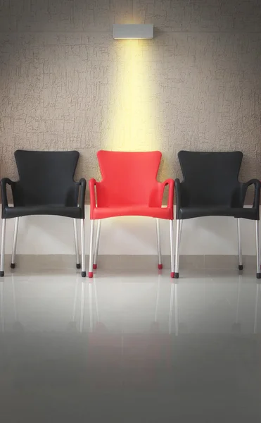 Three chairs in line and light on the middle chair — Stock Photo, Image