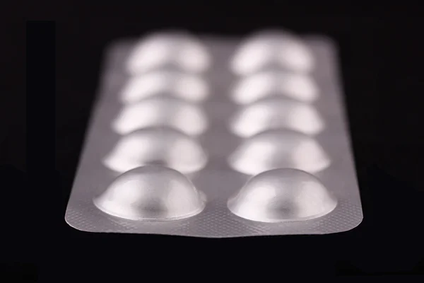 Tablets strip closeup on a black background — Stock Photo, Image