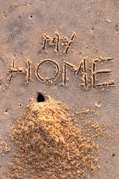 क्रेब छेद और मेरे घर शब्दों के साथ रेत का एक ढेर — स्टॉक फ़ोटो, इमेज