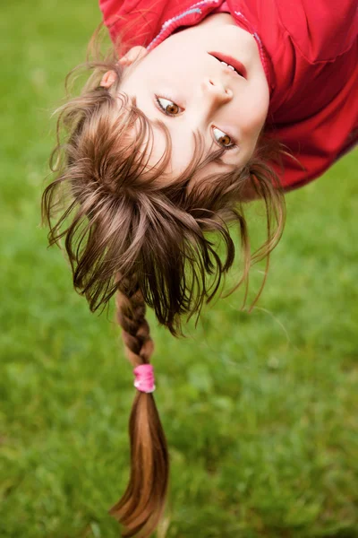 Klein meisje opknoping ondersteboven — Stockfoto
