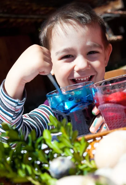 Gelukkige jongen kleurstoffen paaseieren — Stockfoto