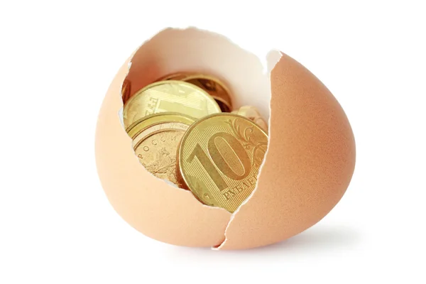 Монети в розбитій яєчній шкаралупі — стокове фото