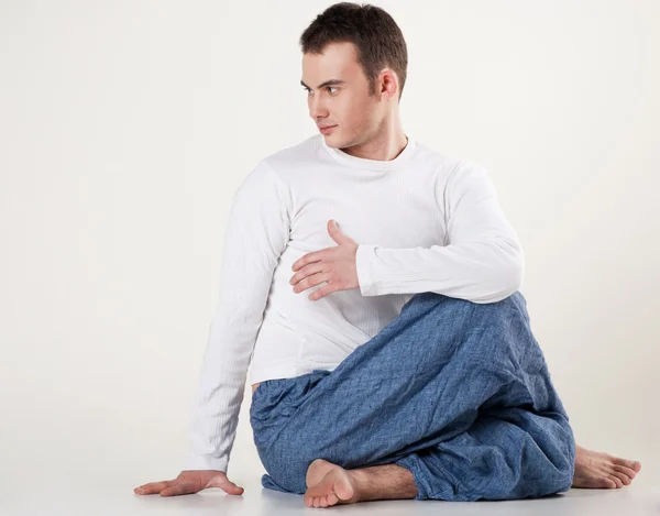 Gesunder junger Mann beim Yoga. Wirbelsäulenverdrehung — Stockfoto