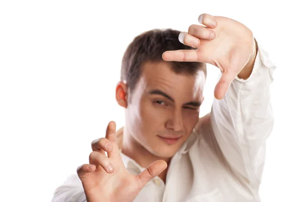 Mladý muž dělat rám s prstem na bílém pozadí — Stock fotografie