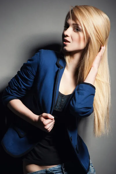 Pózování blondýnka s dlouhými vlasy na grey — Stock fotografie