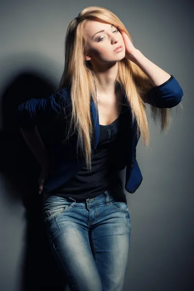 Poseren blonde vrouw met lang haar op grijs — Stockfoto
