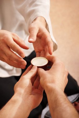 A young man holds a Chinese tea ceremony clipart