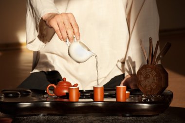 A young man holds a Chinese tea ceremony clipart