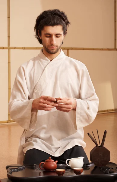 A young man holds a Chinese tea ceremony — Stock Photo, Image