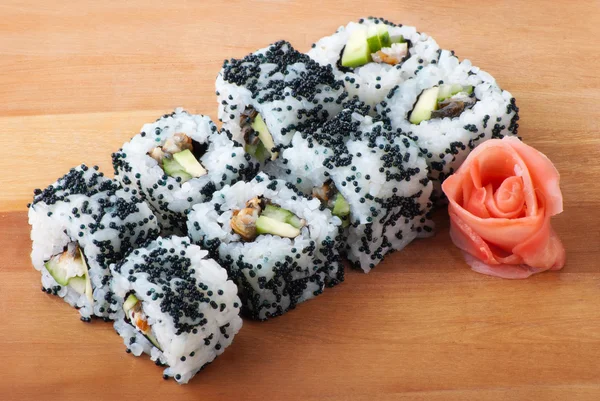 Rollos de sushi de California en placa de madera — Foto de Stock