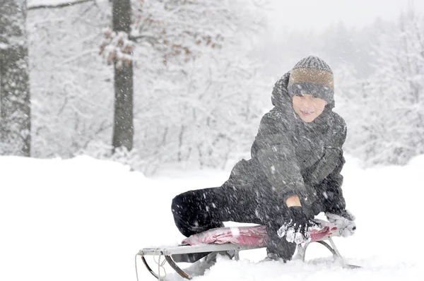 Усміхнений хлопчик зі сніжкою — стокове фото