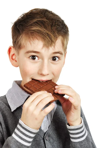 Menino comendo uma barra de chocolate — Fotografia de Stock