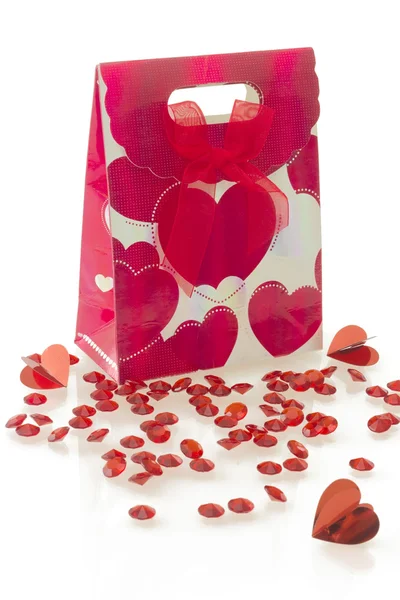 Red gift bag with heart pattern and bow, isolated on white — Stock Photo, Image