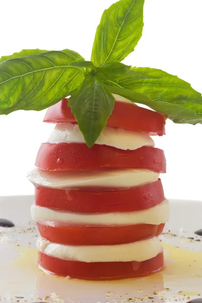 stock image Tower of mozzarella and tomato salad with basil leaf, isolated o