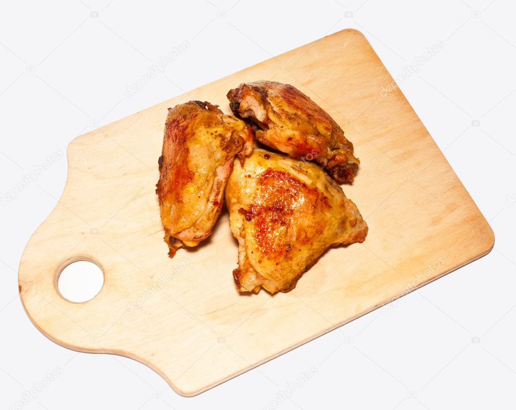 The fried pieces of chicken on a chopping board on a white backg