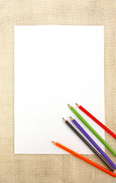Бумага на мешковине с карандашами — стоковое фото