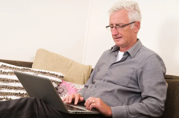 Sénior trabalhando em um laptop — Fotografia de Stock