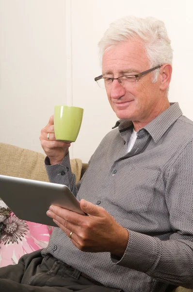 Sênior trabalhando em um tablet pc — Fotografia de Stock