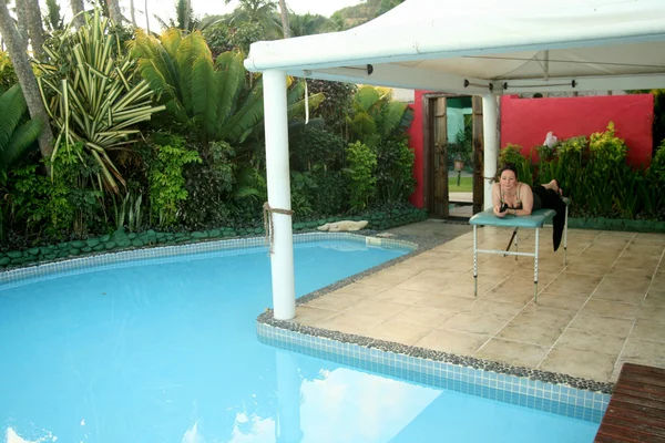 Mulher relaxante junto à piscina — Fotografia de Stock