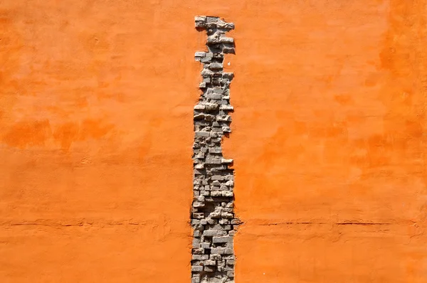 Crack de briques en mur orange — Photo