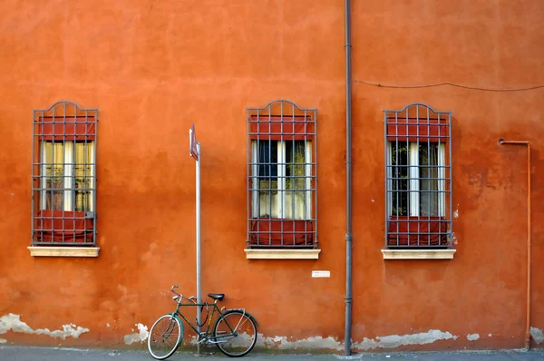 Bicicleta na frente do antigo edifício laranja — Fotografia de Stock