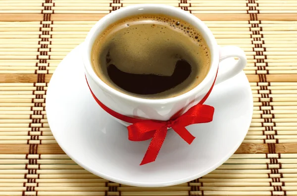 Чашка кофе с красным бантом — стоковое фото
