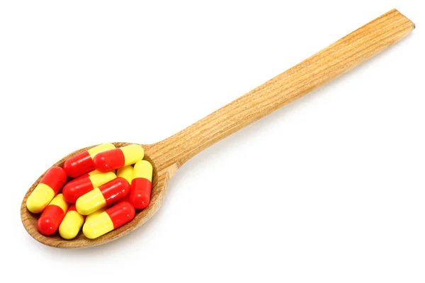 Деревянная ложка с таблетками — стоковое фото
