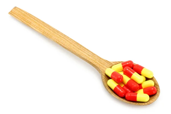 Colher de madeira com pílulas — Fotografia de Stock