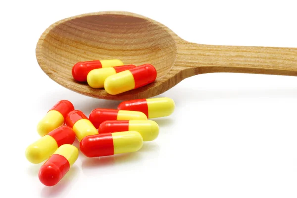 Colher de madeira com pílulas — Fotografia de Stock