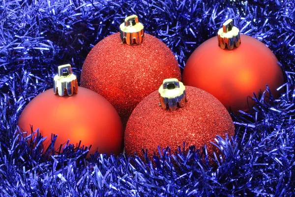 Red Christmas balls with blue tinsel — Stock Photo, Image