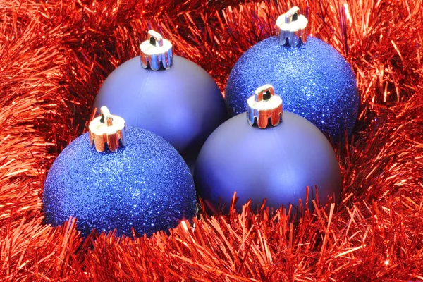 Blue Christmas balls with red tinsel — Stock Photo, Image