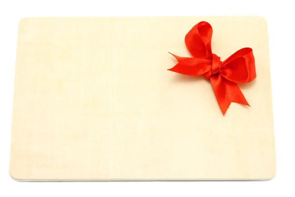Big red holiday bow on a wooden board — Stock Photo, Image