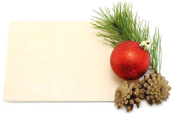 एक वोडेन बोर्ड पर पिनकोन और फायर ट्री के साथ क्रिसमस बॉल — स्टॉक फ़ोटो, इमेज