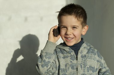 Child talking by mobile phone clipart