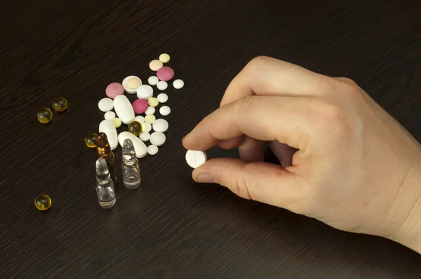 Leki i ręki trzymającej pigułka — Zdjęcie stockowe