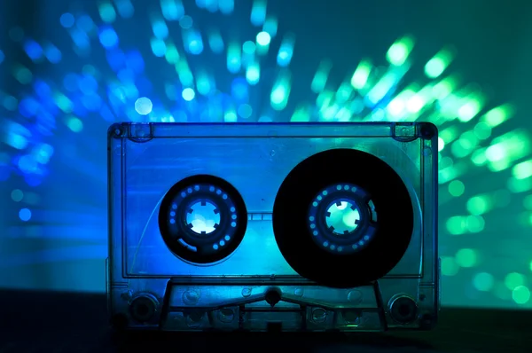 Transparentní kazeta páska a diskotéka světlo pozadí — Stock fotografie