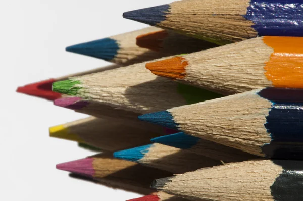 Різнокольорові олівці розташовані на фоні — стокове фото
