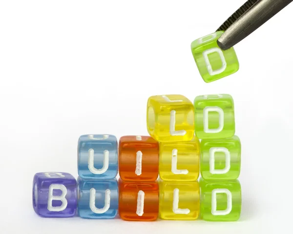 Texto construir em cubos de madeira coloridos — Fotografia de Stock