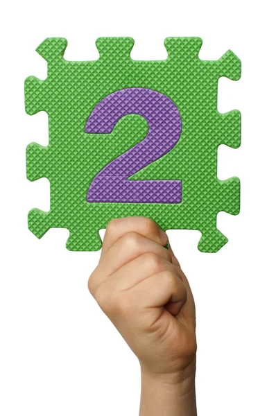 Kinderen hand houder van het nummer twee. witte geïsoleerde nummer — Stockfoto