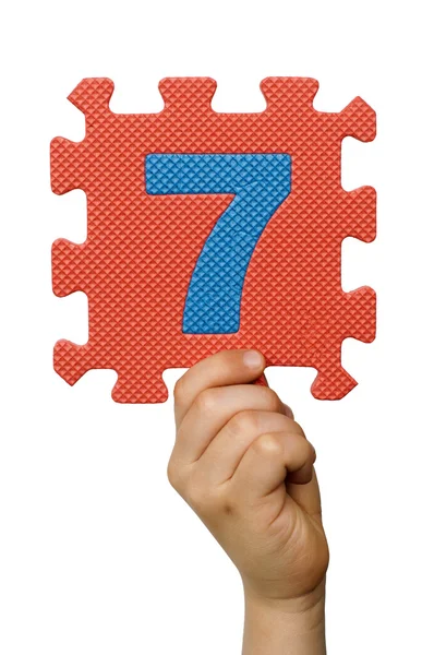 Kinderen hand houder van het nummer zeven. witte geïsoleerde nummer — Stockfoto