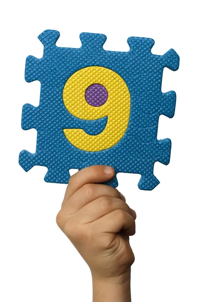 Kinderen hand houder van het nummer negen. witte geïsoleerde nummer — Stockfoto