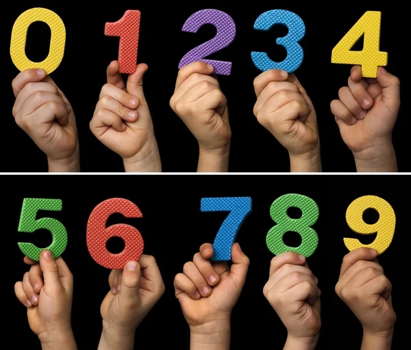 Manos de niños sosteniendo números. Número multicolor aislado negro —  Fotos de Stock