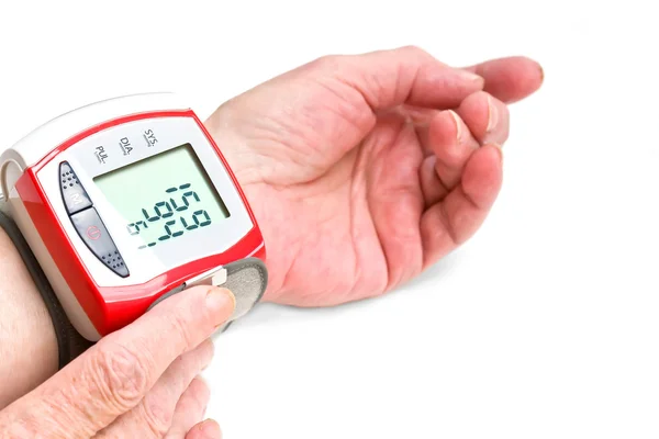 Les mains de la vieille femme mesurant la pression artérielle — Photo