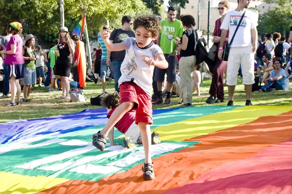 Мальчик танцует на радужном флаге — стоковое фото