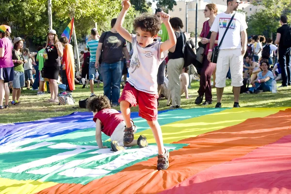 Мальчик играет на радужном флаге — стоковое фото